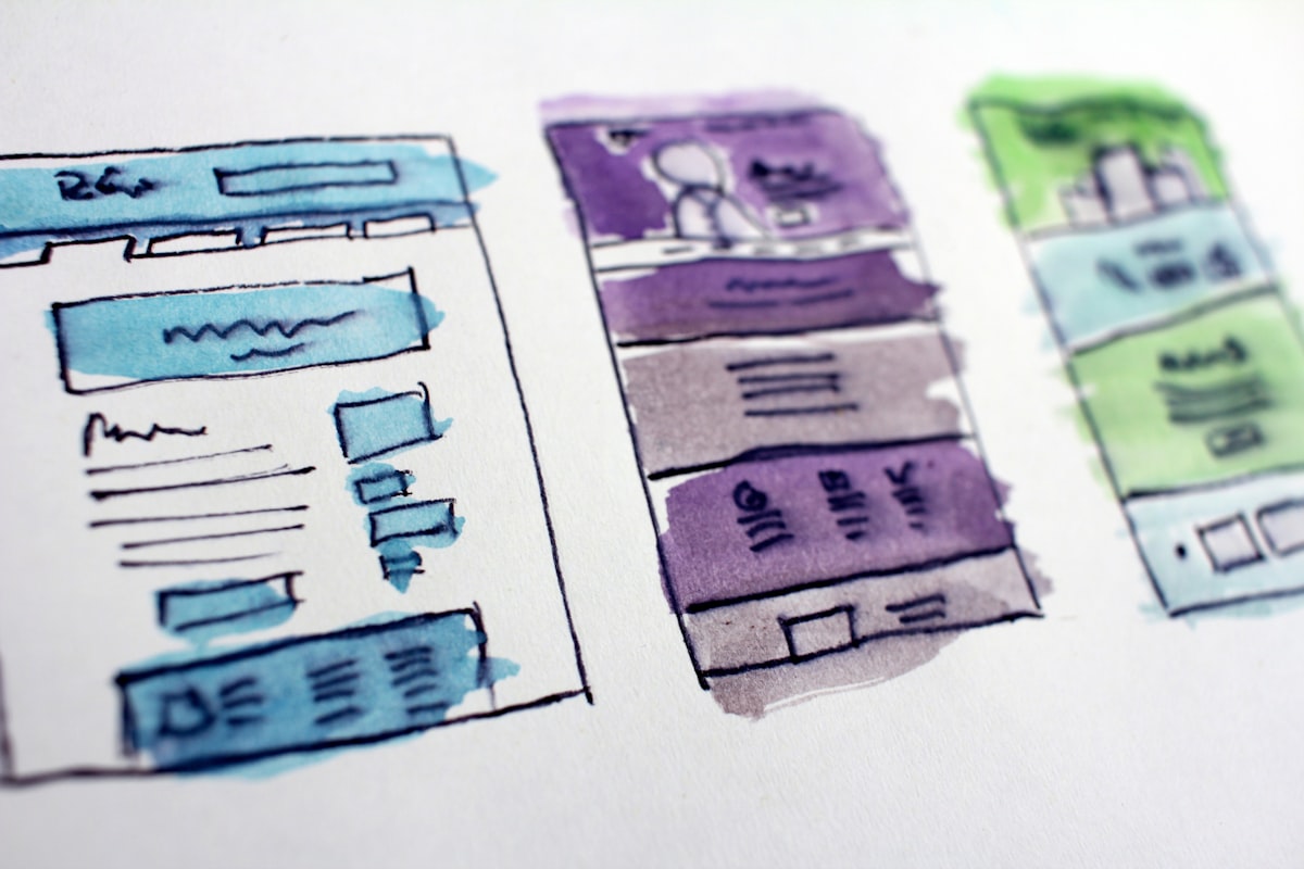 Designer sketching website wireframes at a desk